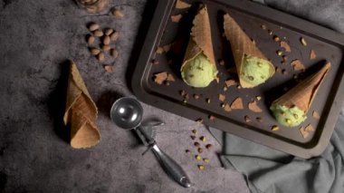 Siyah bir arka planda waffle konileri fıstık dondurması topları.