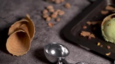 Siyah bir arka planda waffle konileri fıstık dondurması topları.