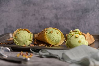 Siyah bir arka planda waffle konileri fıstık dondurması topları.