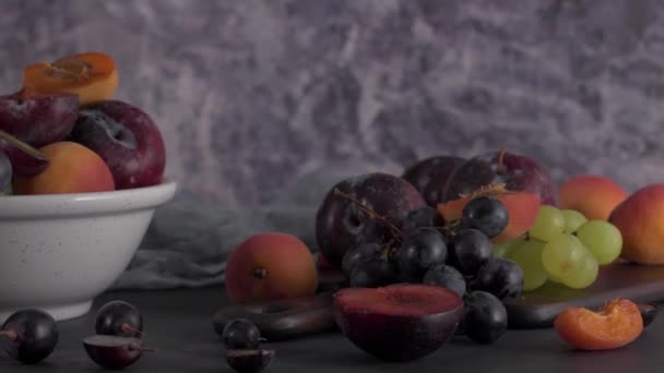 Fruchtstillleben Mit Früchten Auf Weißer Keramikschale Betonmauer Dramatisches Licht Trauben — Stockvideo