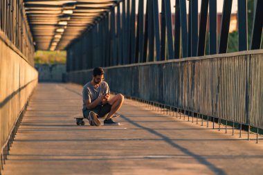 onun kaykay üzerinde oturan genç adam
