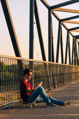 onun kaykay üzerinde oturan genç adam