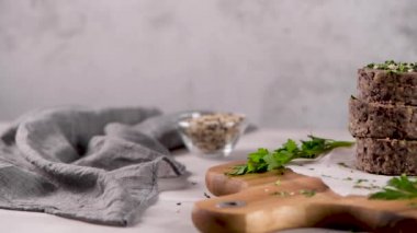 Ahşap kesme tahtası üzerinde maydanoz yaprakları ile siyah fasulye ile Çiğ vejetaryen burger.