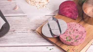 Çiğ vejetaryen burger pancar kökü ve maydanoz yapraklı beyaz fasulye tahta kesme tahtasında..