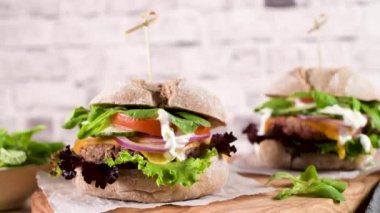 Mutfak tezgahında taze sebzeli ve yoğurt soslu sağlıklı vejetaryen burger..