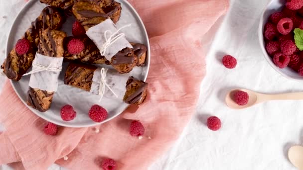 Müsliriegel Mit Erdnüssen Und Schokolade Mit Himbeeren Auf Der Arbeitsplatte — Stockvideo