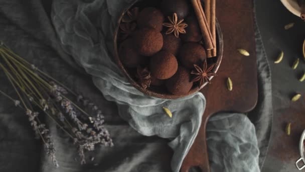 Řemeslné čokoládové lanýže na talíři s kakaovým práškem a arašídy.