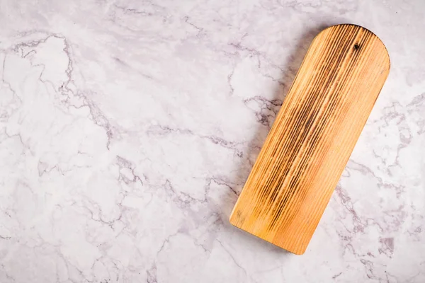 Wooden cutting board on a gray marble background — Stock Photo, Image