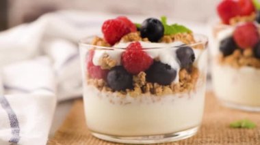 Granola böğürtlen ve ahududu. Açık beyaz ahşap arka planda ev yapımı yoğurt. Sağlıklı gıda konsepti.