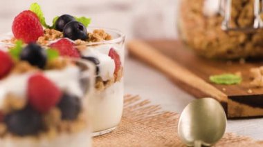 Granola böğürtlen ve ahududu. Açık beyaz ahşap arka planda ev yapımı yoğurt. Sağlıklı gıda konsepti.