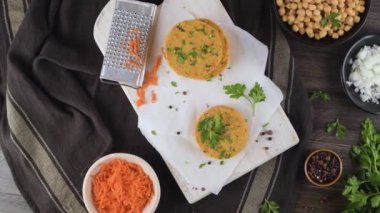 Çiğ vejetaryen burger, nohut, sebze ve maydanozlu mutfak tezgahında..