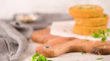 Mutfak tezgahında nohut, sebze ve maydanoz yapraklı çiğ vejetaryen burger..