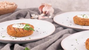 Izgara vejetaryen burger, bezelye, sebze ve seramik tabakta maydanoz yaprakları..