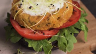 Lezzetli ızgara vejetaryen burgerler nohut ve siyah ekmeğin üstünde sebzeler ve ahşap tezgah..