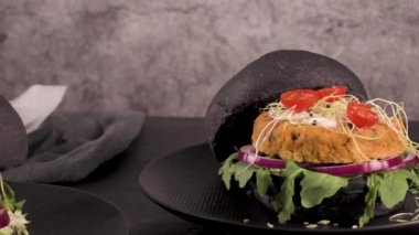 Lezzetli ızgara vejetaryen burgerler nohut ve siyah ekmeğin üstünde sebzeler ve ahşap tezgah..