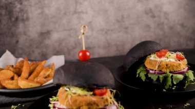 Lezzetli ızgara vejetaryen burgerler nohut ve siyah ekmeğin üstünde sebzeler ve ahşap tezgah..