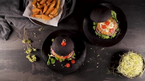 濃い木のカウンターの上に黒パンにひよこ豆や野菜とおいしい焼き野菜バーガー — ストック動画