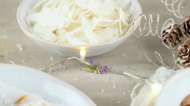 Hindistan cevizi kavrulmuş bademli ev yapımı şekerler. Işıklar ve yıldızlarla süslenmiş bir Noel masasında..