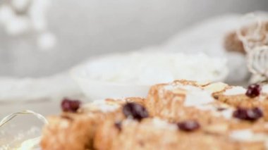 Noel sezonunda ışık ve yıldızlarla süslenmiş bir masada badem, hindistan cevizi ve kızılcıklı tahıl gevreği..