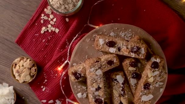 Μπαρ Δημητριακών Αμύγδαλα Καρύδα Και Cranberries Χριστουγεννιάτικο Τραπέζι Διακοσμημένο Φώτα — Αρχείο Βίντεο