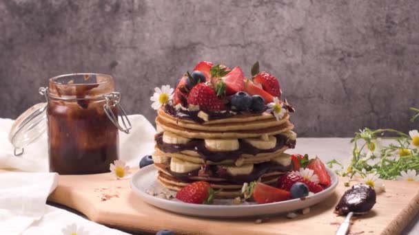 Pfannkuchen Mit Banane Blaubeeren Erdbeeren Und Schokoladensauce Auf Einem Teller — Stockvideo