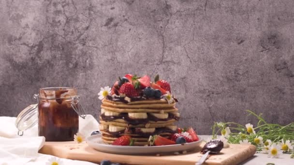 Pfannkuchen Mit Banane Blaubeeren Erdbeeren Und Schokoladensauce Auf Einem Teller — Stockvideo