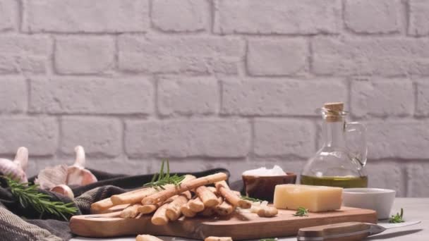 新鮮な焼きたての自家製グリッシーニパンは キッチンカウンターの上にオリーブオイルとローズマリーハーブとヴィンテージ金属グリッドボックスにスティック — ストック動画
