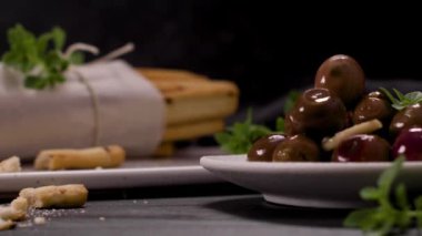 Taze pişmiş ev yapımı Grissini ekmek çubukları beyaz seramik tepside ve mutfak tezgahının üzerinde zeytinyağı ve fesleğen otu ile.