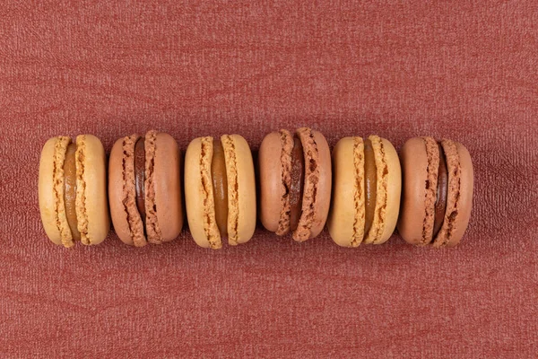 Six Coffee Chocolated Flavoured Macaroons Red Vinyl Background — Stock Photo, Image