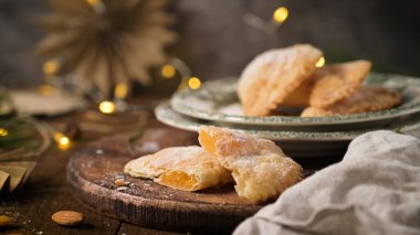 Çıtır hamura sarılmış yumurta ve bademlerden yapılmış hilal şeklinde bir hamur işi. Zanaatkar bir şekilde kesilmiş ve üzerine şeker serpiştirilmiş..