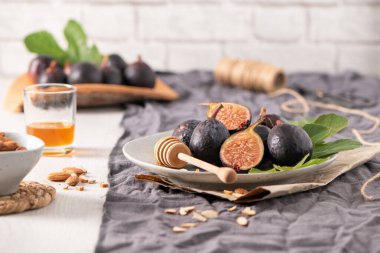 Taze Siyah Görev incirlerinden oluşan kırsal bir hayat. Bazıları canlı kırmızı etlerini ortaya çıkarmak için ortadan ikiye bölünmüş..