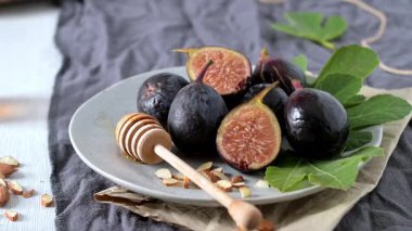 Taze Siyah Görev incirlerinden oluşan kırsal bir hayat. Bazıları canlı kırmızı etlerini ortaya çıkarmak için ortadan ikiye bölünmüş..