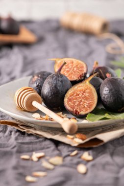 Taze Siyah Görev incirlerinden oluşan kırsal bir hayat. Bazıları canlı kırmızı etlerini ortaya çıkarmak için ortadan ikiye bölünmüş..