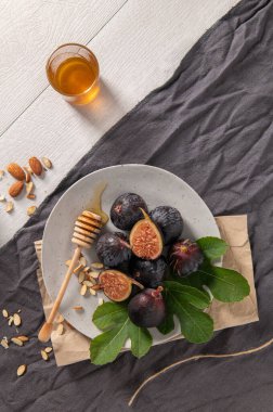 Taze Siyah Görev incirlerinden oluşan kırsal bir hayat. Bazıları canlı kırmızı etlerini ortaya çıkarmak için ortadan ikiye bölünmüş..