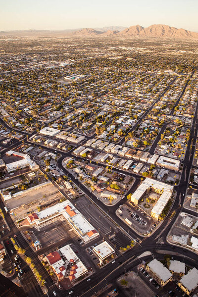 Aerial view across urban suburban communities seen from Las Vegas Nevada with streets, mountains, rooftops, and homes
