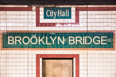 New York City Metro İstasyonu'na belediyedeki vintage kiremit duvar ve Brooklyn Köprüsü'nün işareti ile