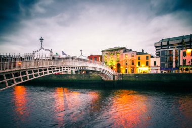 Gün batımında görülen Liffey Nehri üzerinde landmark Ha'Penny köprü görünümü 