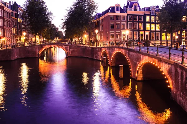 Günbatımı, köprüler, kanallar ve ışıklar ile Amsterdam akşam