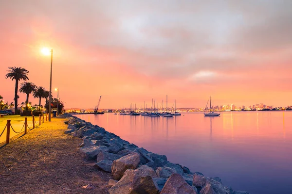 San Diego California şehir manzarası, defne ve tekneler görünümünde renkli gökyüzü altında altın günbatımı