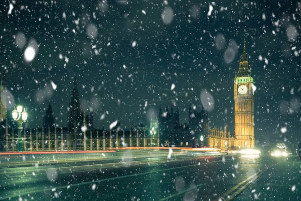 冬季伦敦场景与大本钟和威斯敏斯特修道院在晚上与降雪 — 图库照片
