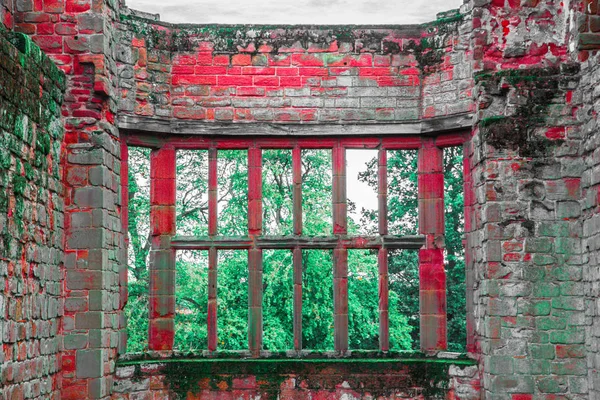 窗户与酒吧在粗糙的石墙中世纪废墟与明亮的红砖看着绿意盎然和树木 — 图库照片