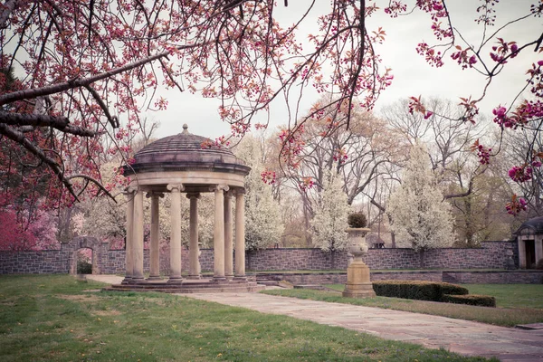 美しい春のガーデン シーンとカラフルな咲く桜の木と古典的な石展望台 — ストック写真