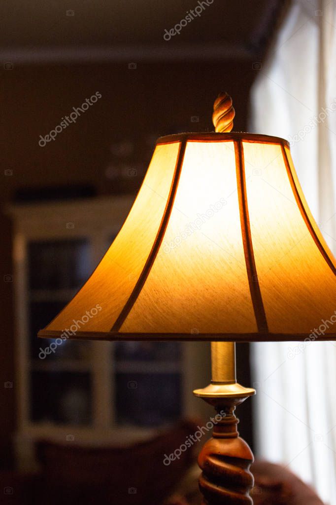 Illuminated lamp with shade in a dimly lit room