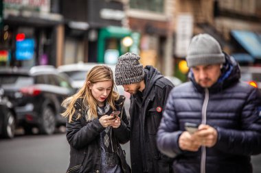  New York City - 14 Aralık 2018: Kış sokak sahne New York'un Manhattan ' cep telefonu meşgul kentsel sokakta genç çift ile