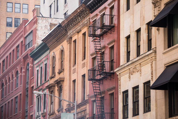 Architectural details on vintage brick apartment building with fire escape in New York City