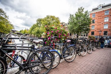 Amsterdam, Hollanda - 31 Ağustos 2018: Amsterdam'dan köprü ve bisikletlerle görülen kanal boyunca görünümü.