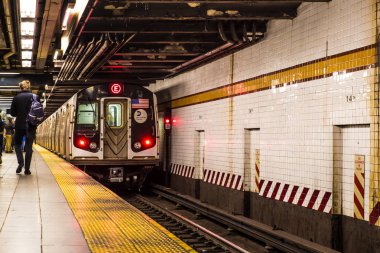 New York City - 3 Aralık 2016: Tren yaklaşırken ve insanlar görünürken metronun yeraltı New York metrosunun içinden görünümü.