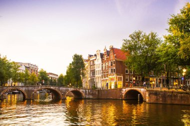 Amsterdam ışık, kanal ve köprü ile akşam görüldü