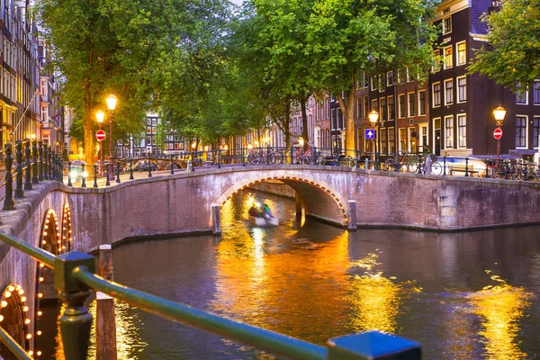 Amsterdam ışık, kanal ve köprü ile akşam görüldü