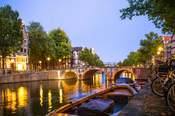 Amsterdam ışık, kanal ve köprü ile akşam görüldü